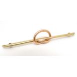 A 14kt gold bar brooch with rose gold knot decoration to centre. Marked Tiffany & Co.