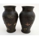 A pair of Japanese Meiji bronze vases with bird amongst plant decoration and applied relief