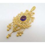 A silver gilt pendant set with central amethyst and profusion of seed pearls and peridot.