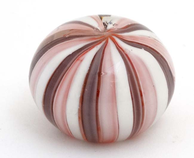 A glass paperweight with banded pink and white decoration approx 3" diameter CONDITION: