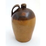 A 19thC staltglazed 2-tone bullet shaped flagon with loop handle.