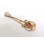 A 10k gold pendant with open work decoration and pink/red stone 1 ¼” long CONDITION:
