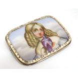 A yellow metal brooch set with hand painted ceramic panel depicting a young girl holding a dove.