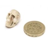 A carved bone ojimie bead formed as a human skull ¾” high CONDITION: Please Note -