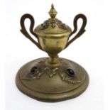 A 19thC brass inkstand with trophy cup style inkwell on circular base and set with 6 banded agate