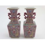 A pair of Chinese twin handled square form vases with flared rims decorated in polychrome enamels