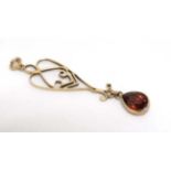 A yellow metal open work pendant set with garnet drop 1 ½” long CONDITION: Please