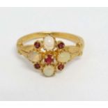 A silver gilt ring set with opal like cabochon and red stones.