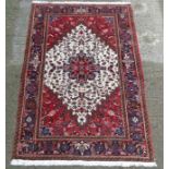 Carpet / Rug : A handmade woollen rug with red central image , blue border ,