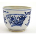 A Chinese blue and white tea bowl decorated with scrolls and fan shaped floral cartouches.