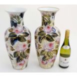 A matched pair of large Oriental style vases decorated in polychrome with flowers and foliage on a