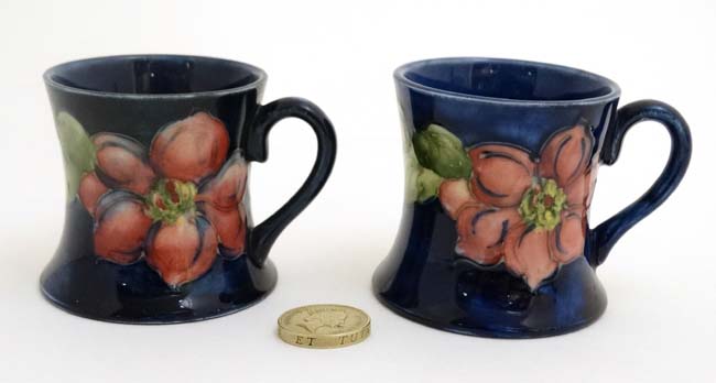 A pair of Moorcroft Miniature ' Clematis ' pattern tankards on a cobalt blue ground ,