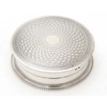 A silver powder compact of circular form with engine turned decoration.