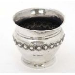 A silver pot / small vase with embossed floral decoration.