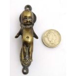 A 20thC small brass door knocker in the form of a stylised kewpie doll.