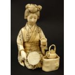 A 19thC Japanese ivory okimono of a kneeling female figure making tea. Signed under .