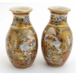 A pair of Japanese Satsuma vases, decorated with figures and mountainous landscape,