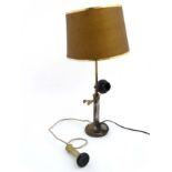 An old electric lamp formed form a candlestick telephone with shade.