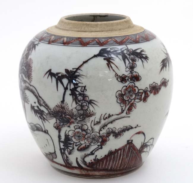 A Chinese red, black and white vase decorated with cherry blossom and bamboo on a rocky outcrop,