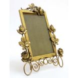 A brass easel / strut frame with roses to borders.