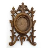 A Victorian Black Forest? carved frame with easel / strut back, to fit a small oval photograph.