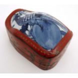 A Chinese shaped red lacquered box and cover with gilt decoration and blue and white ceramic panel