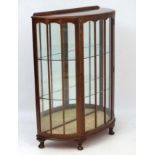 An early - mid 20thC walnut demi-lune display cabinet with lacquered decoration.