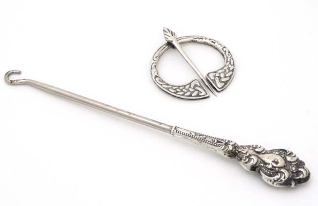 A silver handled button hook marked 'Sterling' together with a Celtic penanular brooch marked '