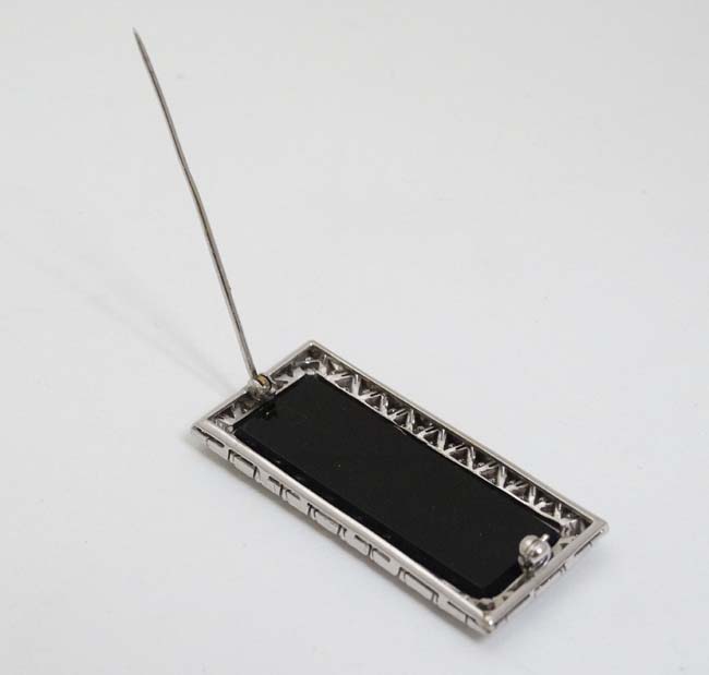 An unusual Art Deco style brooch set with central black onyx surrounded bordered by diamonds in a - Image 2 of 4