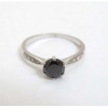 An 18ct white gold ring set with central black coloured diamond flanked by 4 diamonds to each