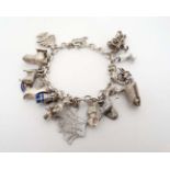 A silver charm bracelet set with 14 various silver and silver plate charms.