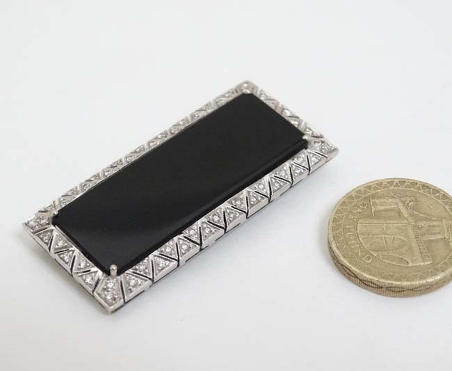An unusual Art Deco style brooch set with central black onyx surrounded bordered by diamonds in a - Image 3 of 4