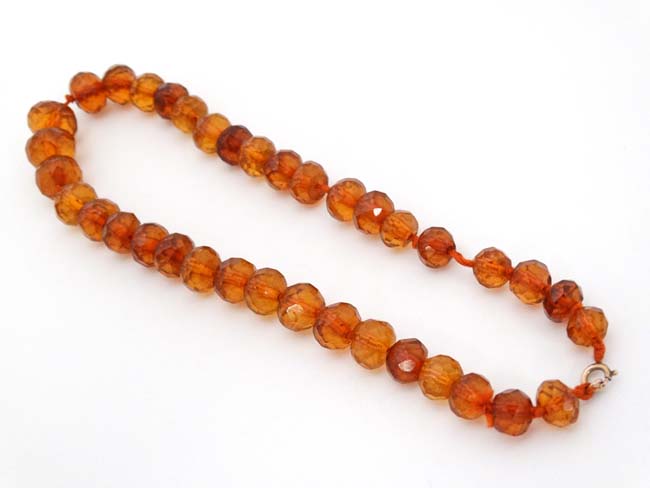 A string of graduated facet cut amber coloured beads. - Image 2 of 3