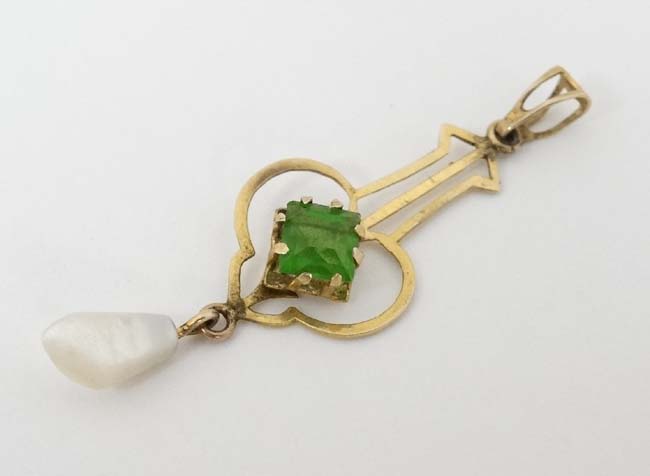 A gilt metal pendant set with green stone and mother of pearl drop CONDITION: