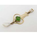A gilt metal pendant set with green stone and mother of pearl drop CONDITION: