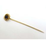 A 14k gold stick pin surmounted by a blue stone 2 ½" long CONDITION: Please Note -