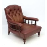 An early 20thC manner of Howard button back armchair with oak frame and faux leather covering 36