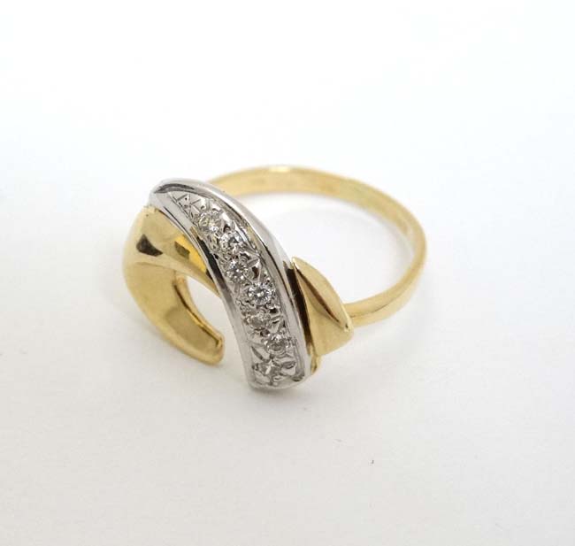 A 9ct gold ring with abstract design to top set with band of diamonds CONDITION: