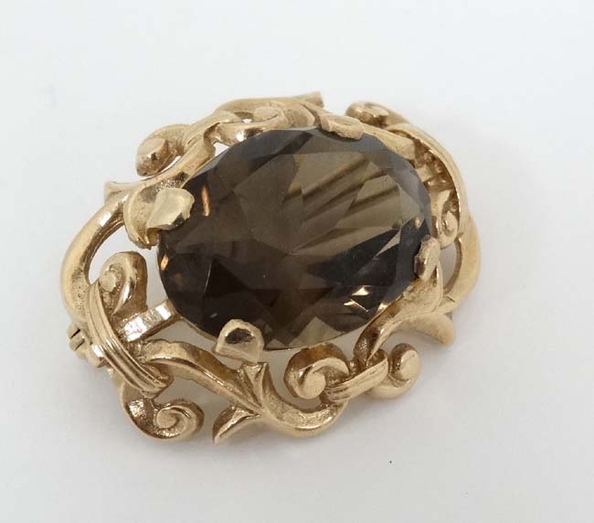 A 9ct gold brooch set with central facet cut smokey quartz within a scrolling mount. - Image 5 of 5