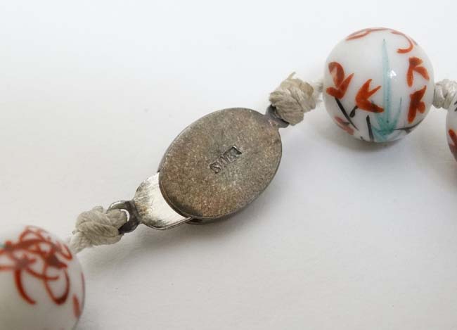 A string of Oriental beads with hand painted decoration and silver clasp. - Image 2 of 4