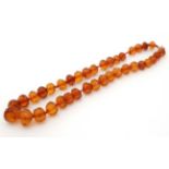 A string of graduated facet cut amber coloured beads.