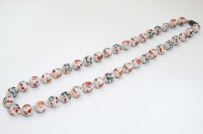 A string of Oriental beads with hand painted decoration and silver clasp.
