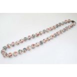 A string of Oriental beads with hand painted decoration and silver clasp.