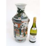 A large Chinese famille verte twin handled vase decorated with figures and a pagoda in a garden