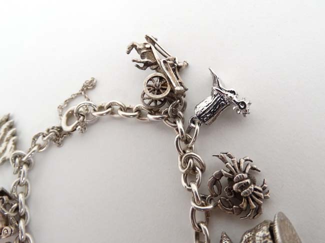 A silver charm bracelet set with 14 various silver and silver plate charms. - Image 5 of 5