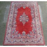 Carpet / Rug : a finely woven red ground small carpet with a floral and geometric central medallion,