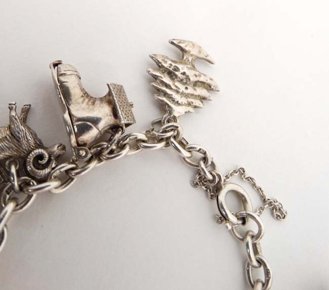 A silver charm bracelet set with 14 various silver and silver plate charms. - Image 4 of 5