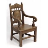 A late Victorian oak elbow chair with solid seat having carved decoration 42 1/4" high