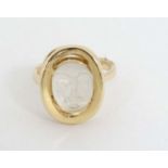 A 14k gold ring set with moonstone cabochon with man in the moon style face decoration.