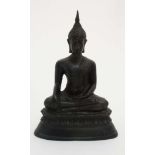 An Oriental cased patinated bronze figure of a seated buddaha on lotus flower base,